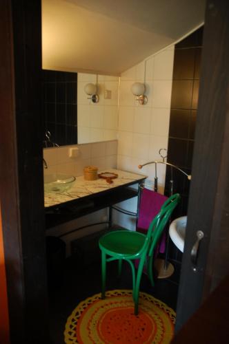 La salle de bains est pourvue d'une chaise verte et d'un lavabo. dans l'établissement Garden Villa Lahti, à Lahti