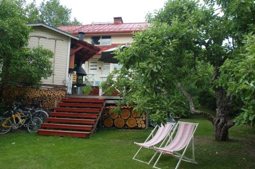 deux chaises et un arbre devant une maison dans l'établissement Garden Villa Lahti, à Lahti