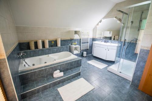 uma casa de banho com uma banheira, um chuveiro e um lavatório. em House of Adventure - The Base to explore Slovenia em Laze v Tuhinju