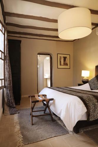 a bedroom with a large bed and a table at Le Petit Hôtel du Flouka in Lalla Takerkoust