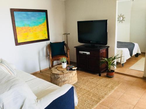sala de estar con TV y cama en El atardecer, en Puerto del Rosario