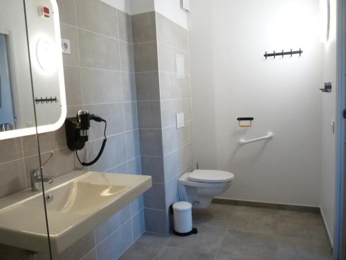 La salle de bains est pourvue de toilettes et d'un lavabo. dans l'établissement L'Horloge Gourmande, à Donzère