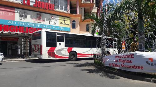 a bus is parked on the side of a street at The Monalysa Suites & Residence in Grand Baie