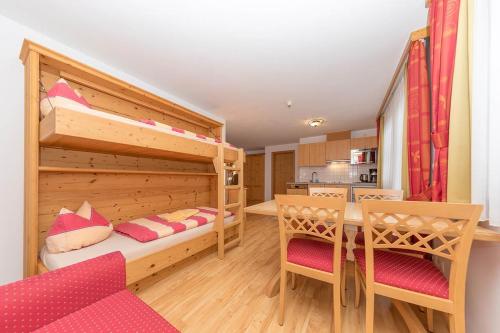 een slaapkamer met een stapelbed en een tafel en stoelen bij Hubertushof Ferienwohnungen in Gerlos