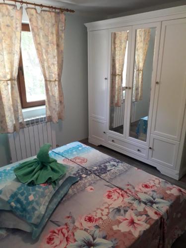 a bedroom with a bed and a cabinet and a window at La pastravaria Cerna in Râu de Mori