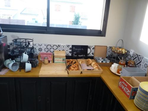 una encimera con una bandeja de pan y una ventana en L'Horloge Gourmande, en Donzère