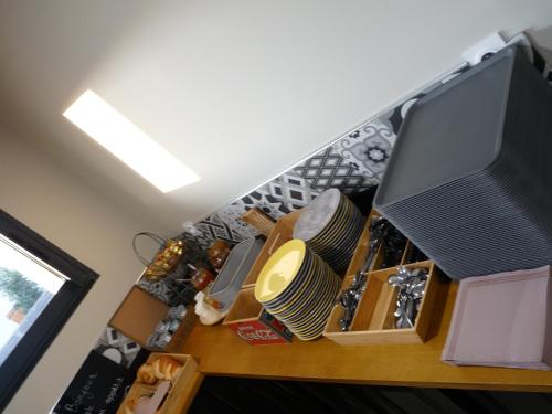 Una sala de estar con un televisor y una mesa. en L'Horloge Gourmande, en Donzère