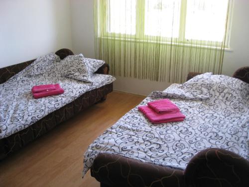 two beds in a room with pink towels on them at Apartman Daca Apatin in Apatin