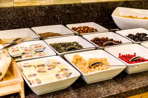 a counter with trays of different types of food at Wohlfühlhotel Berg Heil in Holzgau