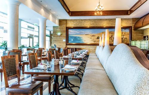 a restaurant with tables and chairs and a large couch at Danat Jebel Dhanna Resort in Jebel Dhanna