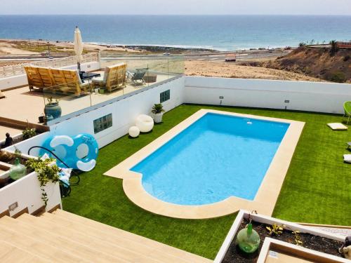 una piscina en la azotea de una casa con playa en El atardecer, en Puerto del Rosario