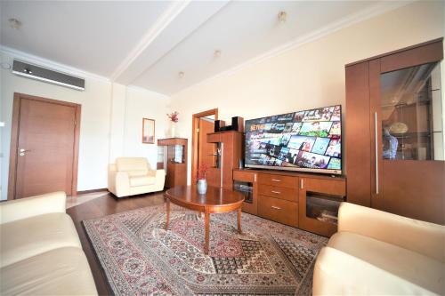 a living room with a table and a tv at Amazing location next to the beach jomas str in Jūrmala