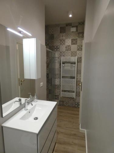 a white bathroom with a sink and a mirror at Villa Allende in Forte dei Marmi in Forte dei Marmi