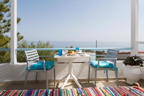 a table and chairs on a balcony with the ocean at Ferma Hill Apartments in Ferma