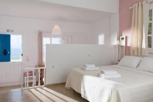 a bedroom with a white bed with towels on it at Ferma Hill Apartments in Ferma
