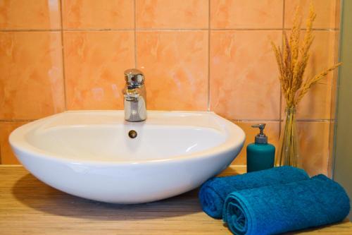 a bathroom sink with two towels on a table at Lubāna mitrāja informācijas centrs in Abaine