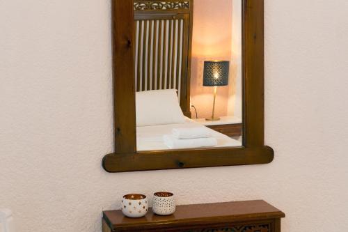 a mirror on a wall with a bed in a room at Ferma Hill Apartments in Ferma
