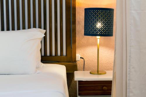 a bedroom with a bed and a lamp on a table at Ferma Hill Apartments in Ferma