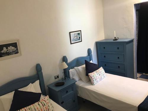 プラヤ・デ・サンティアゴにあるApartamento El Cascajoのベッドルーム1室(ベッド2台、青いドレッサー付)