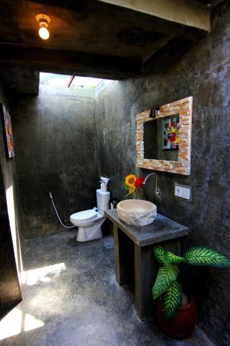 a bathroom with a sink and a toilet in a room at De Vir House in Canggu