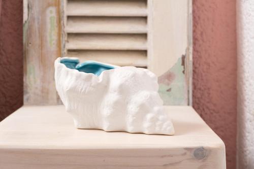 a white vase sitting on top of a table at Ferma Hill Apartments in Ferma