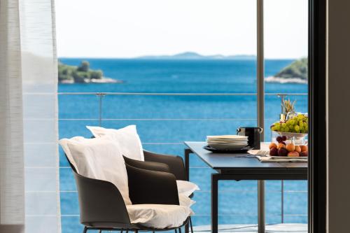 een eetkamer met een tafel en uitzicht op de oceaan bij Villa Desire in Prizba