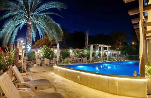 a swimming pool at night with chairs and a palm tree at Galazio Asteri I in Loutrópolis Thermís