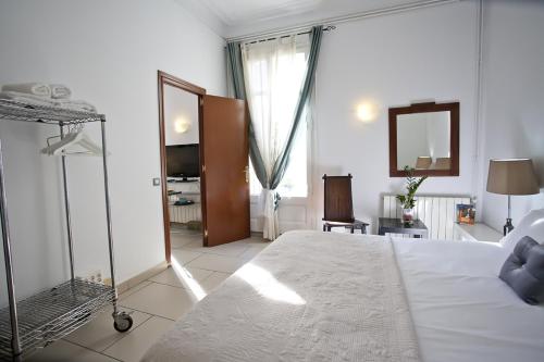 1 dormitorio con cama blanca y espejo en BALCONIES AND VIEWS in City center en Barcelona