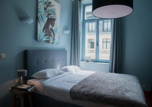 ブリュッセルにあるSmartflats - Fripiers Brusselsの青いベッドルーム(ベッド1台、窓付)