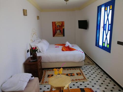 a bedroom with a bed and a table and a couch at Riad Zawia in Essaouira