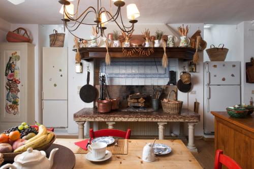 a kitchen with a fireplace and a table with fruits at Villa il Galero in Asolo