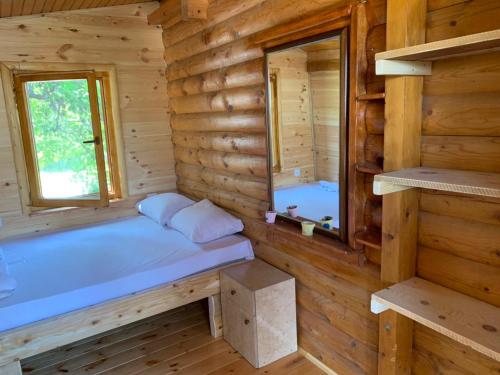 a log cabin with a bed and a window at Holiday Home Kite House in Ulcinj