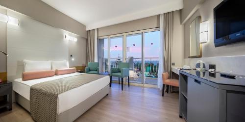 um quarto de hotel com uma cama e uma cozinha com vista em Trendy Aspendos Beach Hotel em Side