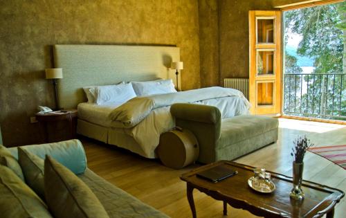 a bedroom with a bed and a couch and a table at Luma Casa De Montaña in Villa La Angostura