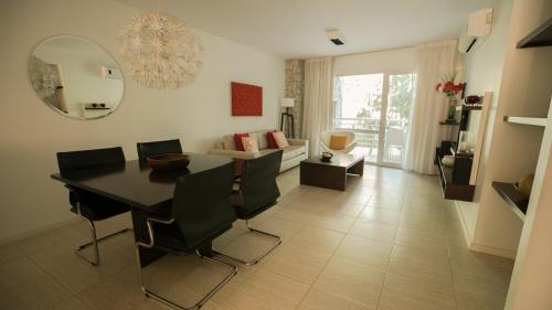 a living room with a table and chairs and a couch at Sea Point By D&G in Carilo