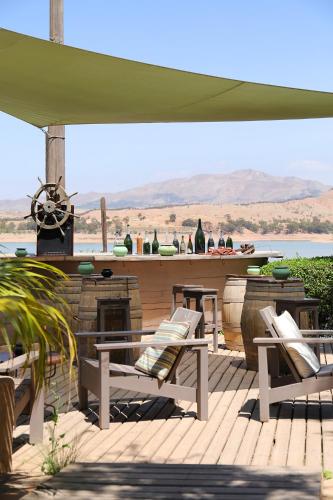 a deck with chairs and a bar with a view at Le Petit Hôtel du Flouka in Lalla Takerkoust