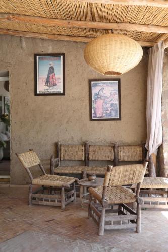 a room with chairs and tables and a large chandelier at Le Petit Hôtel du Flouka in Lalla Takerkoust