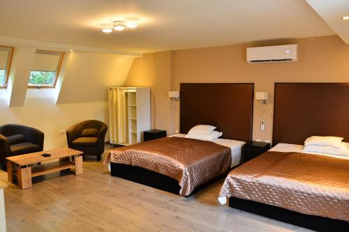 a hotel room with two beds and two chairs at Room4U Apartment in Balatonszemes