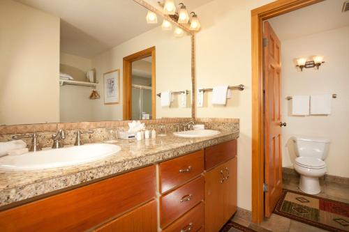 a bathroom with two sinks and a toilet at Evergreen Condominiums by Keystone Resort in Keystone