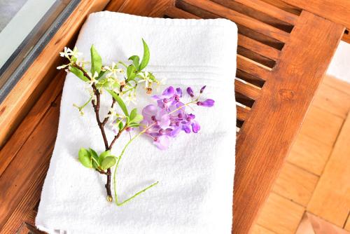 a white towel with purple flowers on it on a table at Casa al Sole in Morcote