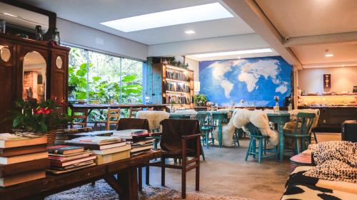 a room with a table and chairs and a large painting at Work Hotel Design in São Leopoldo