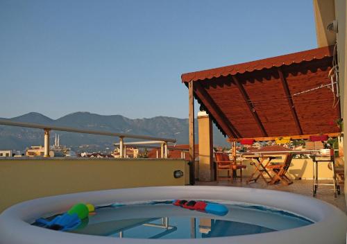 a bath tub sitting on top of a balcony with a table at Friends Terrace in Tirana