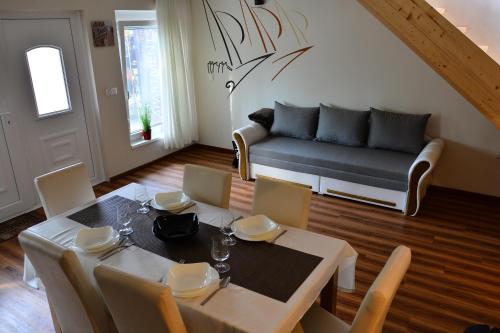 ein Esszimmer mit einem Tisch und einem Sofa in der Unterkunft Room4U Apartment in Balatonszemes