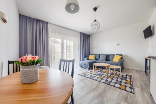 ein Wohnzimmer mit einem Tisch und einem blauen Sofa in der Unterkunft Apartamenty Sun & Snow Pięć Mórz z basenem in Sianożęty