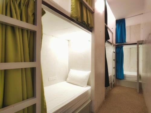 Beds In Garden Hostel في ايبوه: غرفة بسريرين بطابقين مع ستائر خضراء