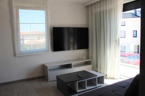 a living room with a couch and a flat screen tv at Pansion Leggero in Krk