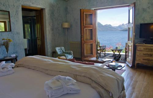 a bedroom with a large bed with a view of the water at Luma Casa De Montaña in Villa La Angostura
