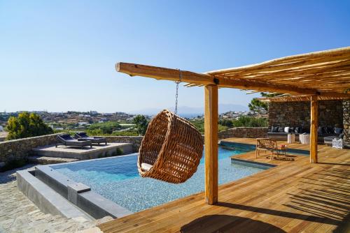 a swimming pool with a hammock on a house at Ikies of Mykonos in Mýkonos City