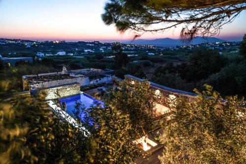 a villa with a swimming pool at dusk at Ikies of Mykonos in Mýkonos City