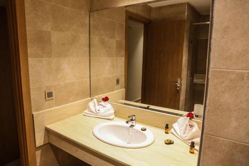 ein Badezimmer mit einem Waschbecken und einem großen Spiegel in der Unterkunft LE VOYAGEUR MARRAKECH in Marrakesch
